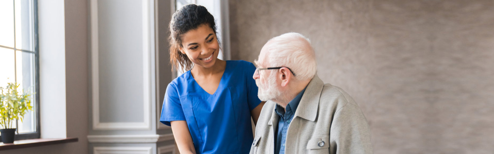 A caregiver assists an elderly man